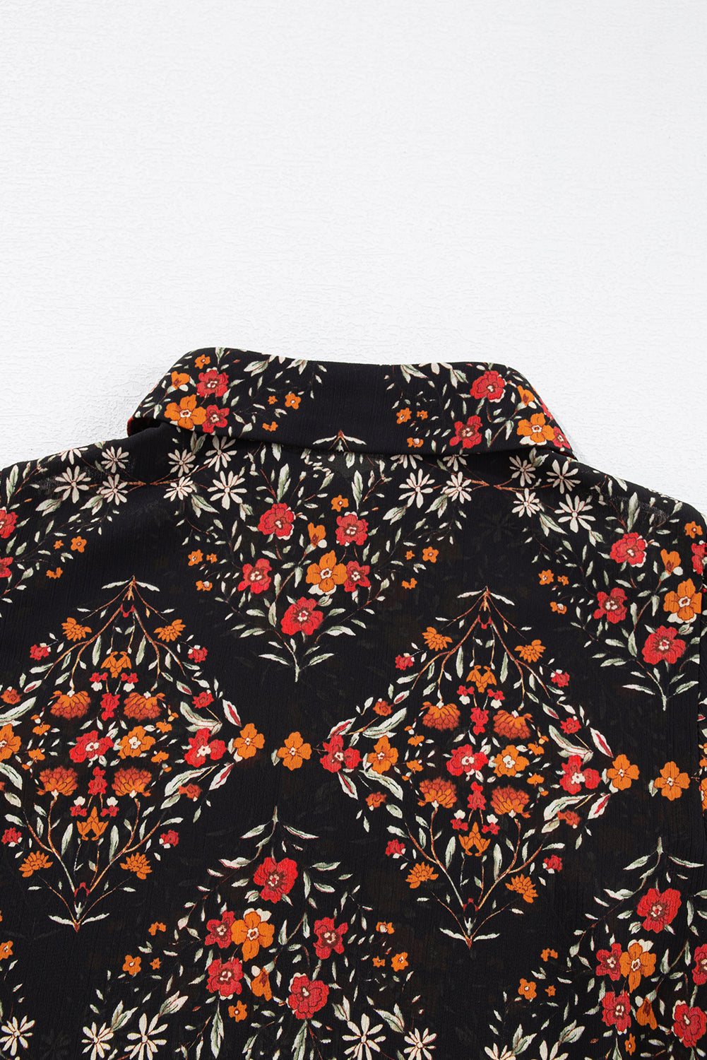Chemise noire à imprimé floral et manches bouffantes boutonnées