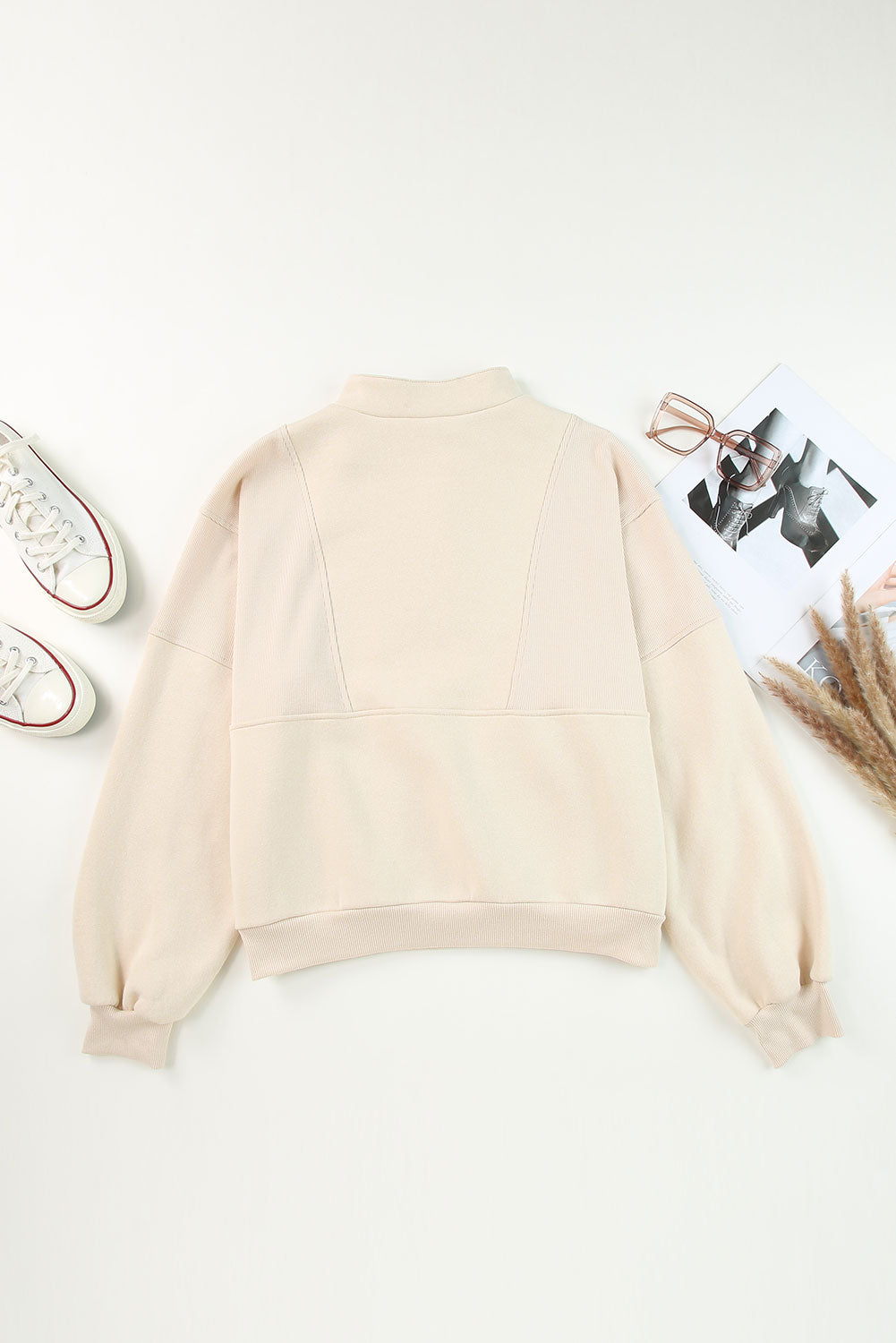 Sudadera informal de color albaricoque con media cremallera, cuello alto y costuras expuestas.