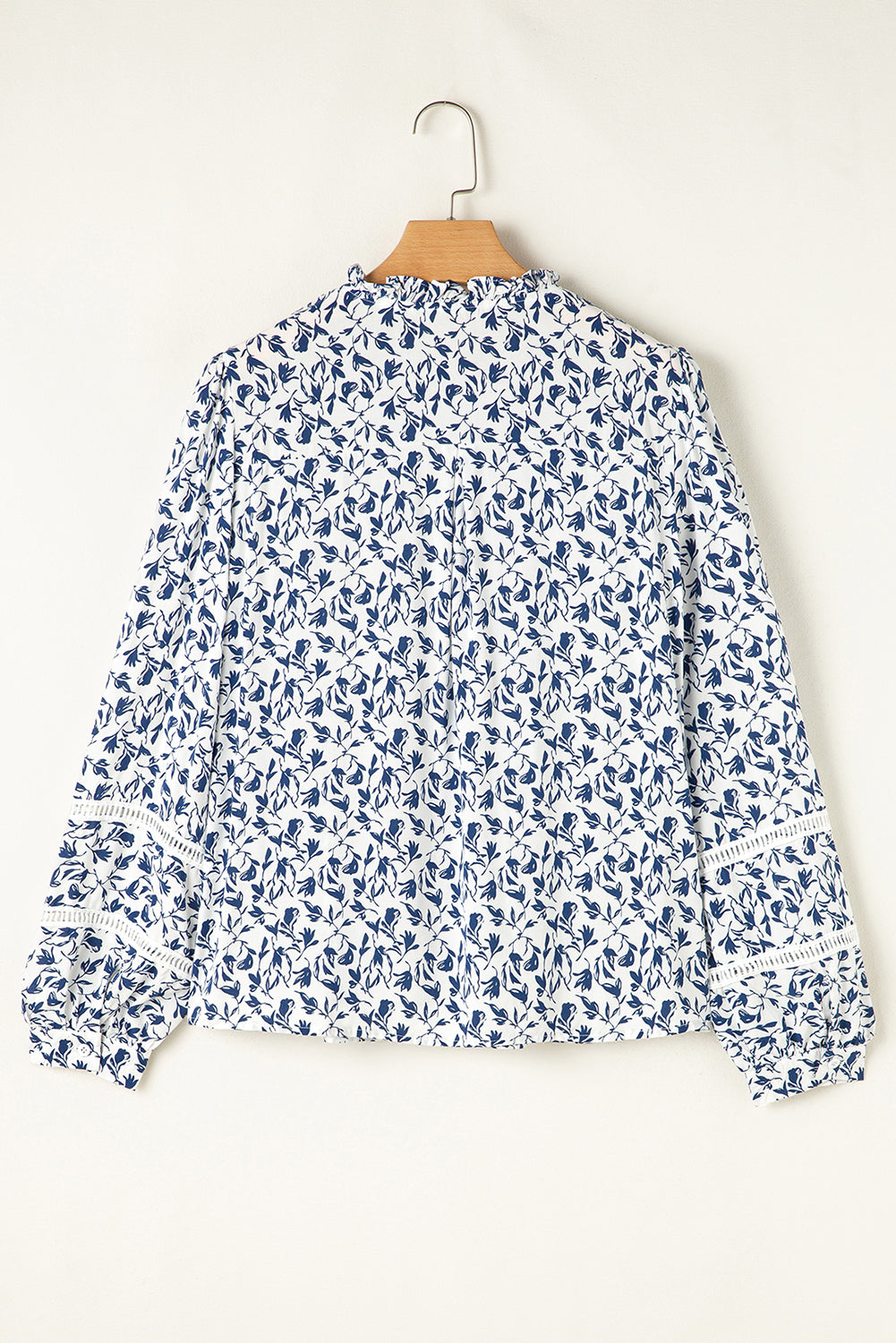 Camisa de otoño con mangas abullonadas, detalle de encaje y estampado floral azul