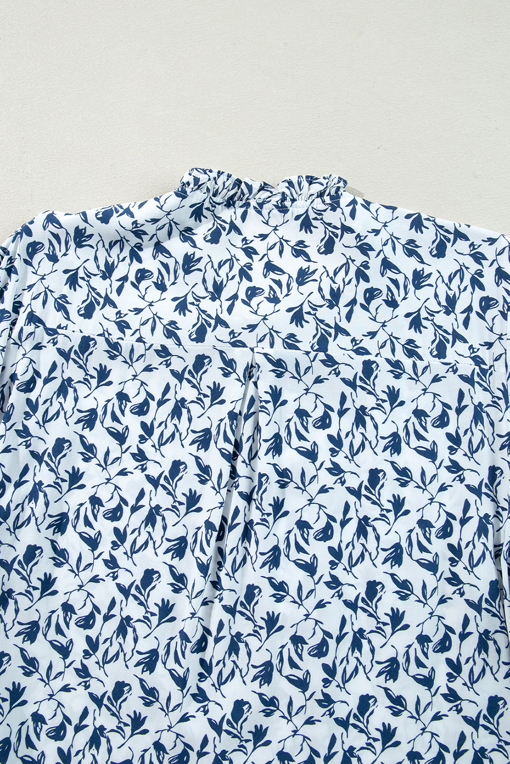 Camisa de otoño con mangas abullonadas, detalle de encaje y estampado floral azul
