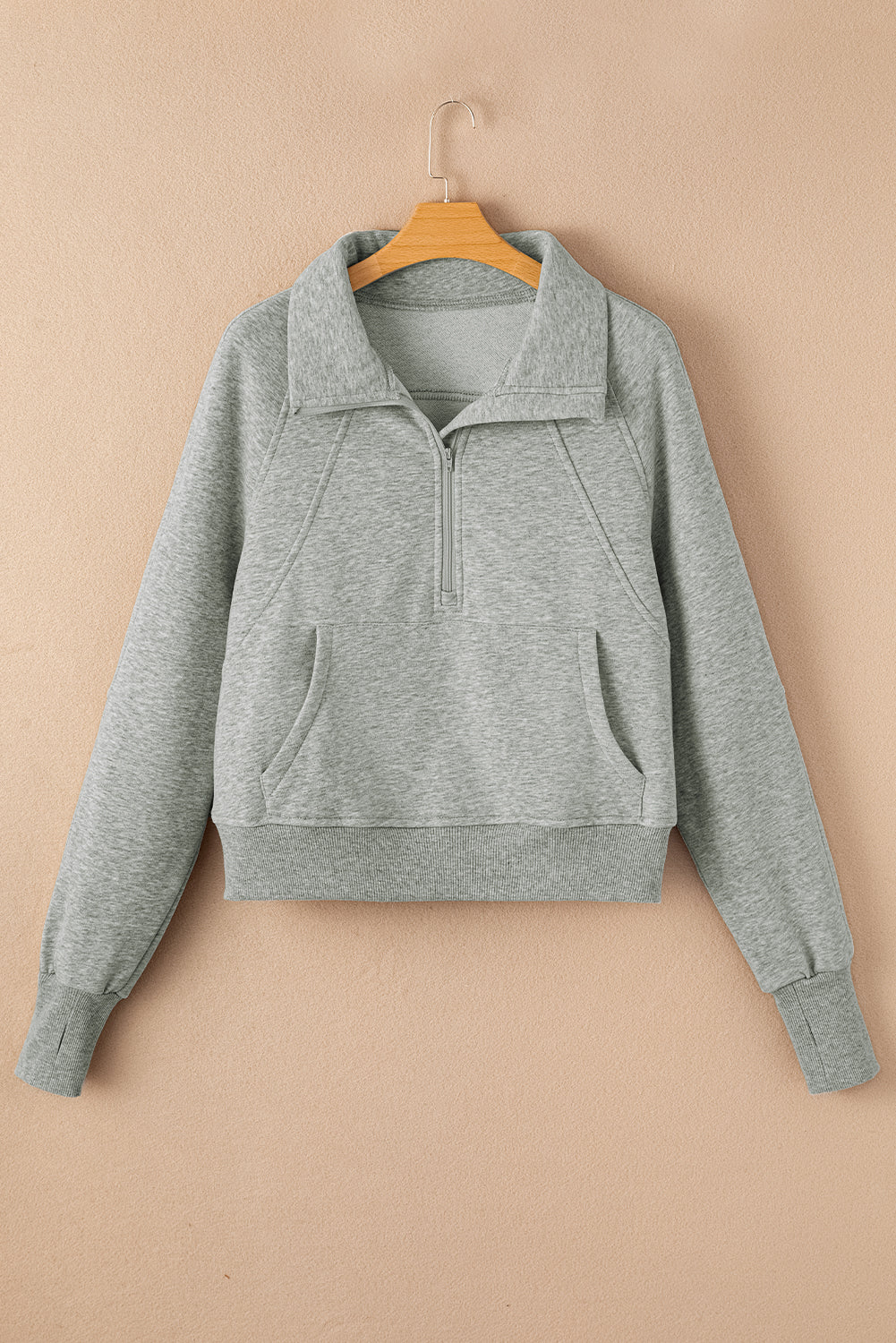 Sudadera gris con cuello alto, cremallera y mangas con abertura para los pulgares acanaladas