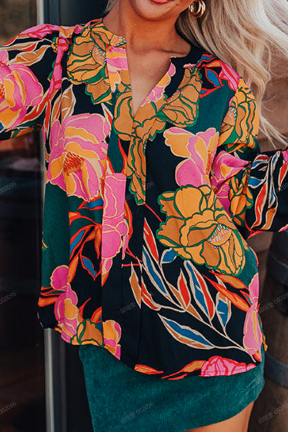 Blusa negra con estampado floral, puños fruncidos, mangas abullonadas y escote en V