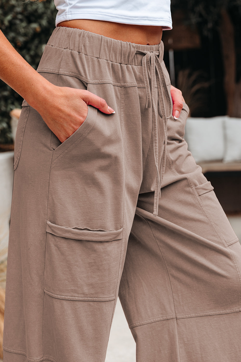 Pantalón cargo de pierna ancha, color gris humo con lavado mineral, costuras expuestas, cintura elástica con cordón ajustable.