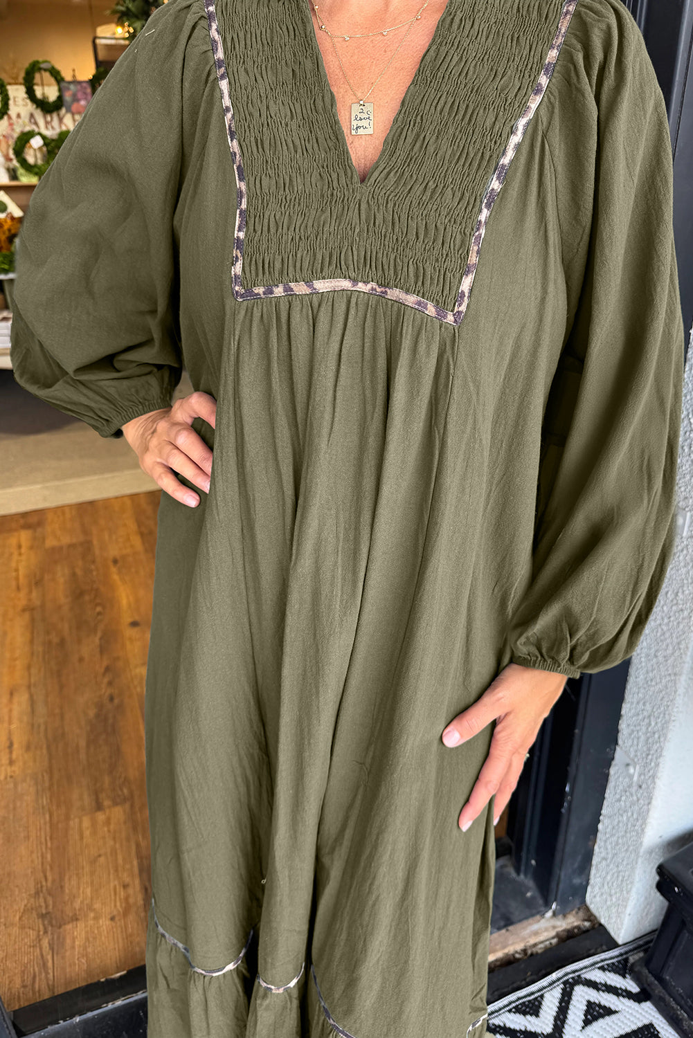 Vestido largo verde con cuello en V, detalle fruncido y ribete de leopardo en contraste