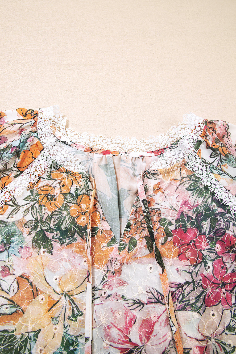 Chemisier rose à imprimé floral, dentelle brodée et col fendu, manches longues