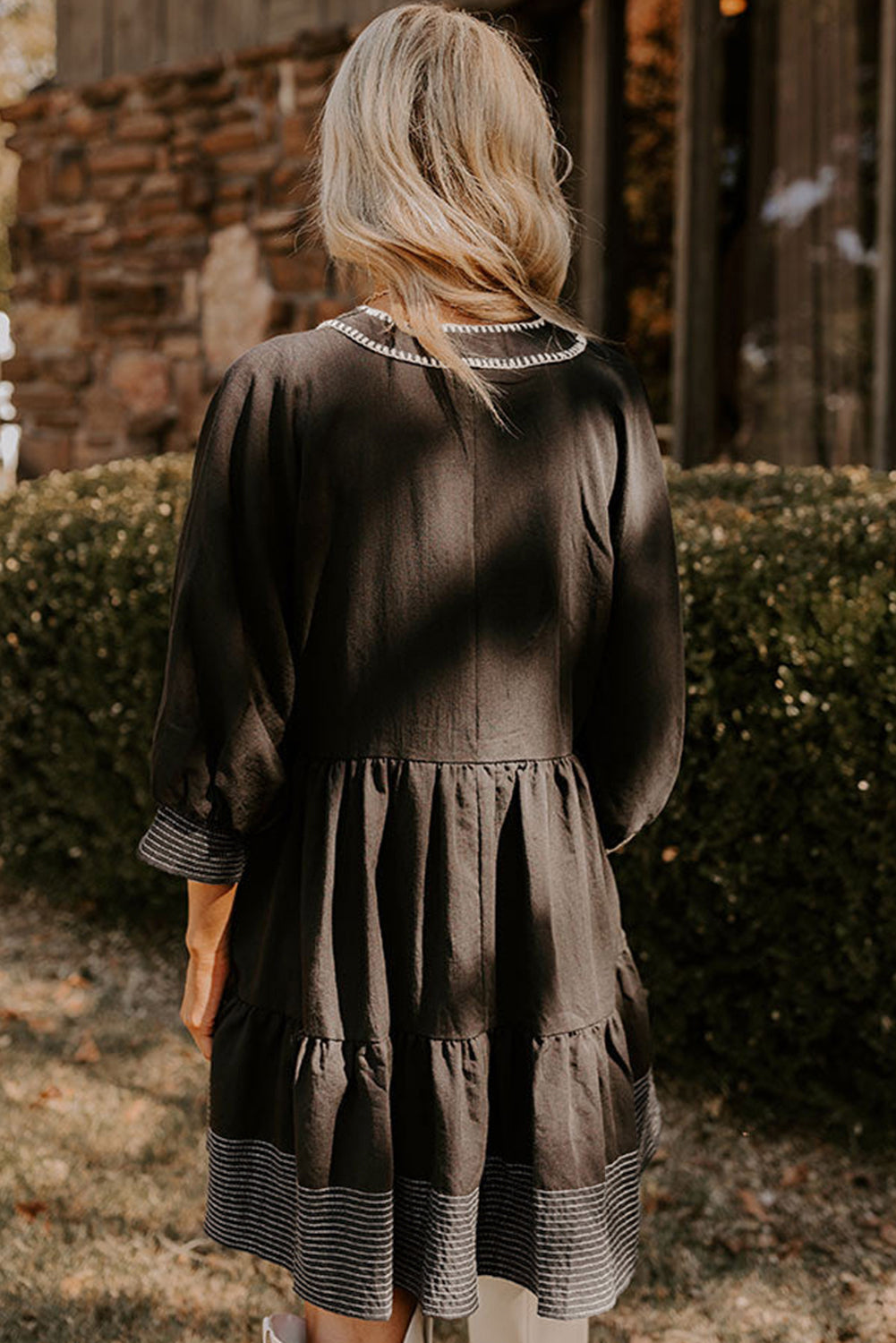 Vestido corto negro con escote en V y mangas 3/4 con costuras en contraste