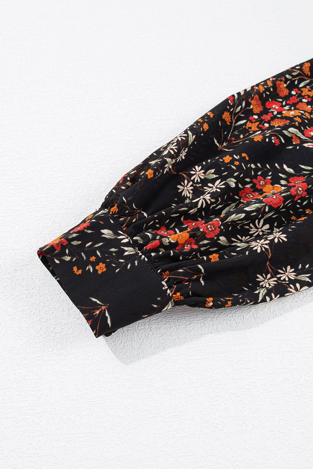 Chemise noire à imprimé floral et manches bouffantes boutonnées