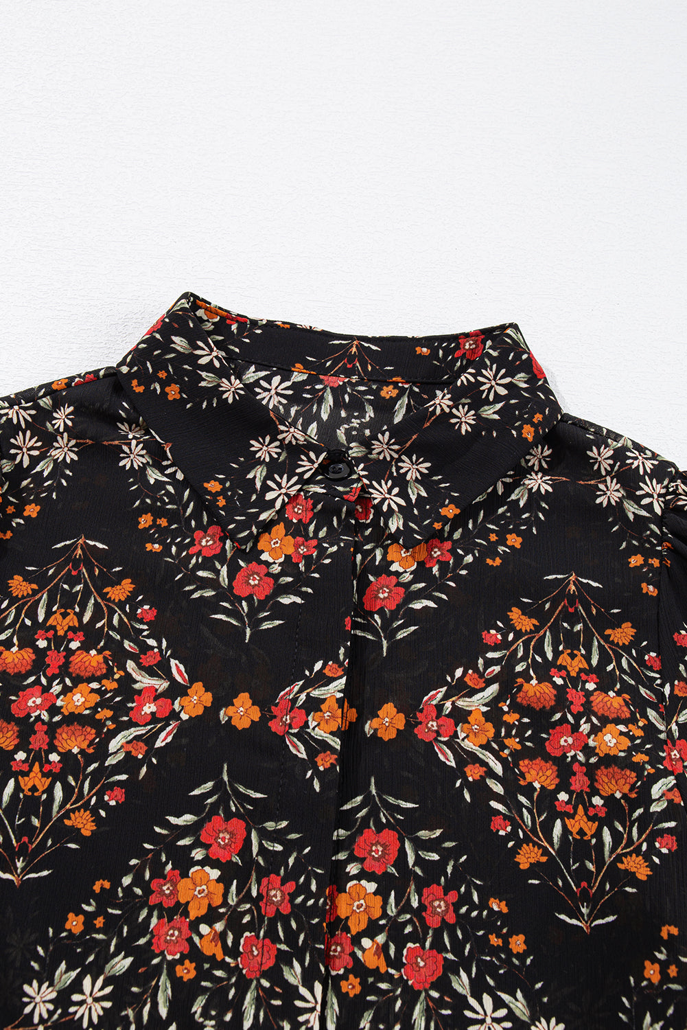 Chemise noire à imprimé floral et manches bouffantes boutonnées