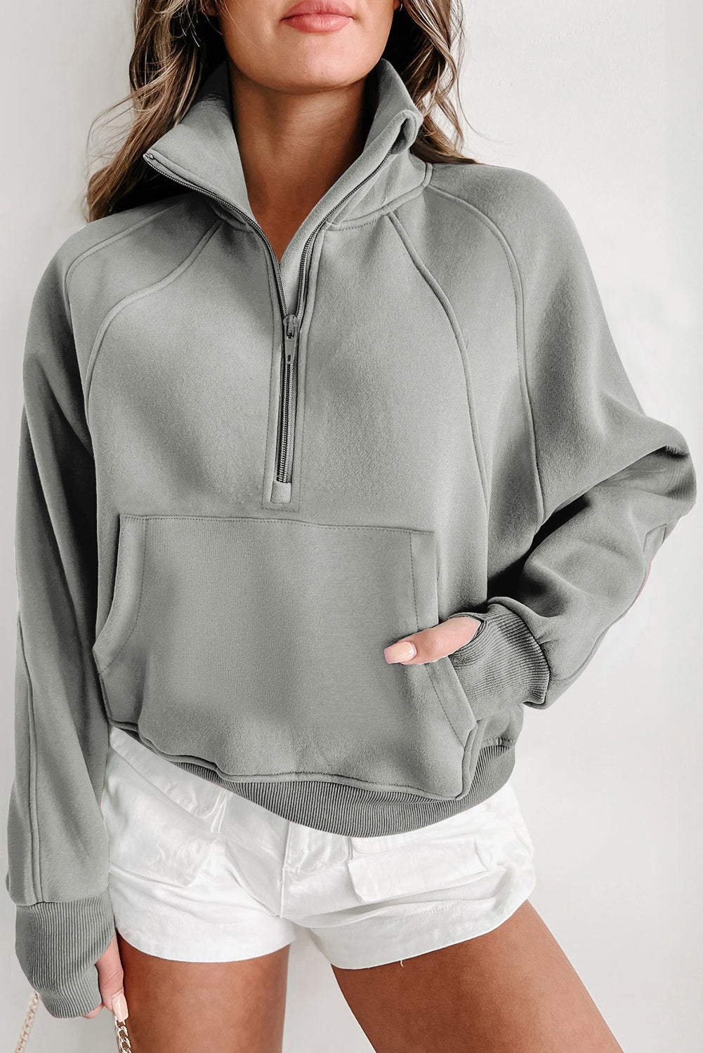 Sudadera gris con cuello alto, cremallera y mangas con abertura para los pulgares acanaladas