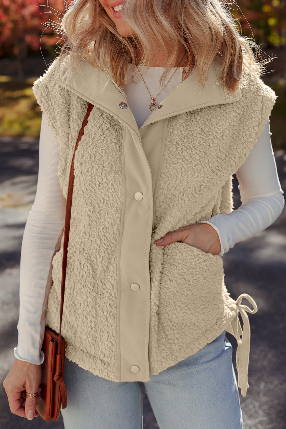 Gilet beige en fausse fourrure avec boutons-pression sur le devant et nœud sur le côté