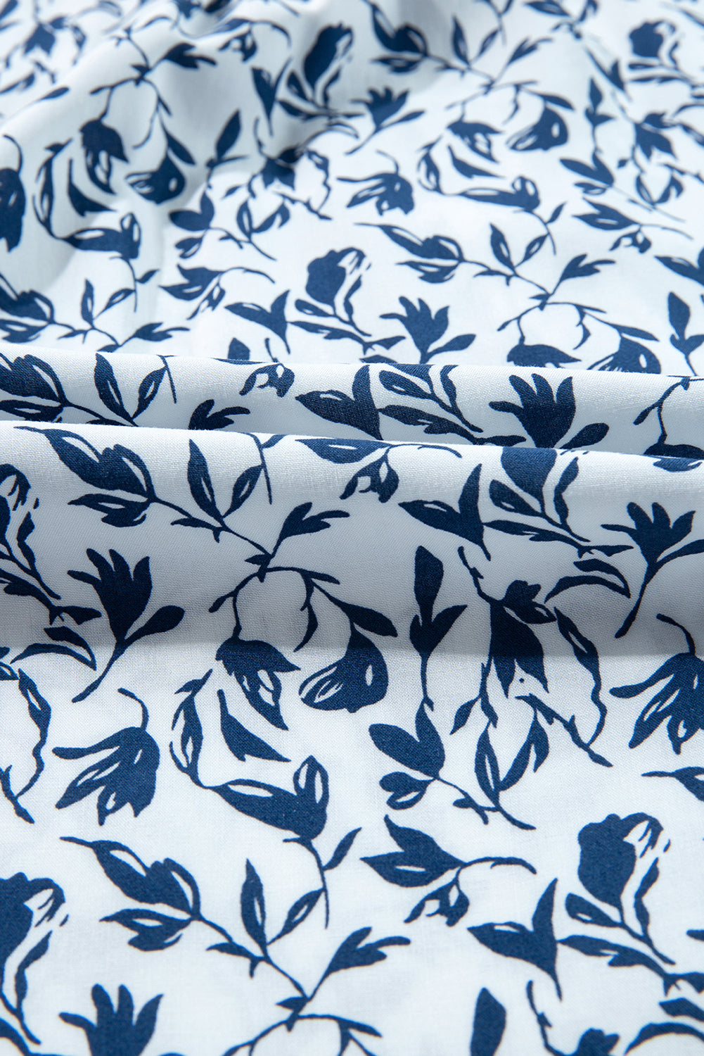 Camisa de otoño con mangas abullonadas, detalle de encaje y estampado floral azul