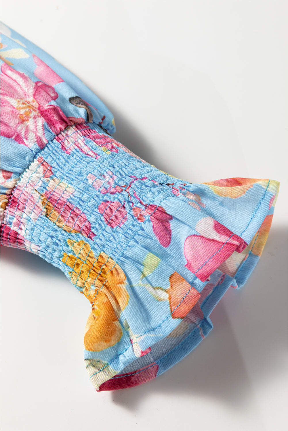 Chemisier bleu ciel à fleurs, poignets froncés, manches volantées, col en V