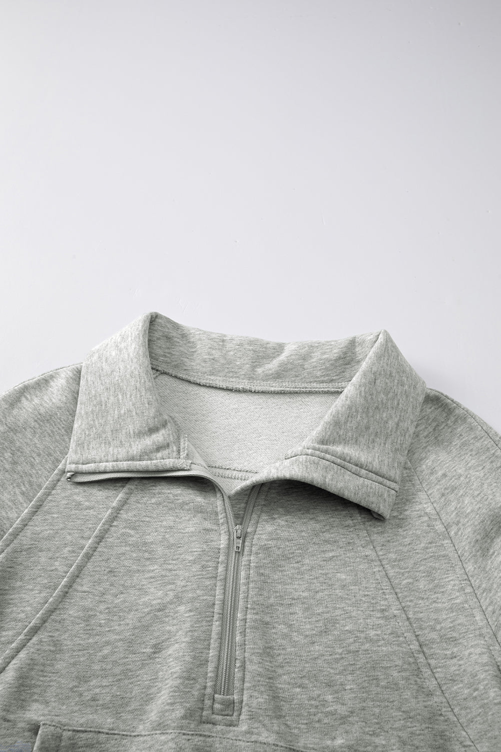 Sudadera gris con cuello alto, cremallera y mangas con abertura para los pulgares acanaladas