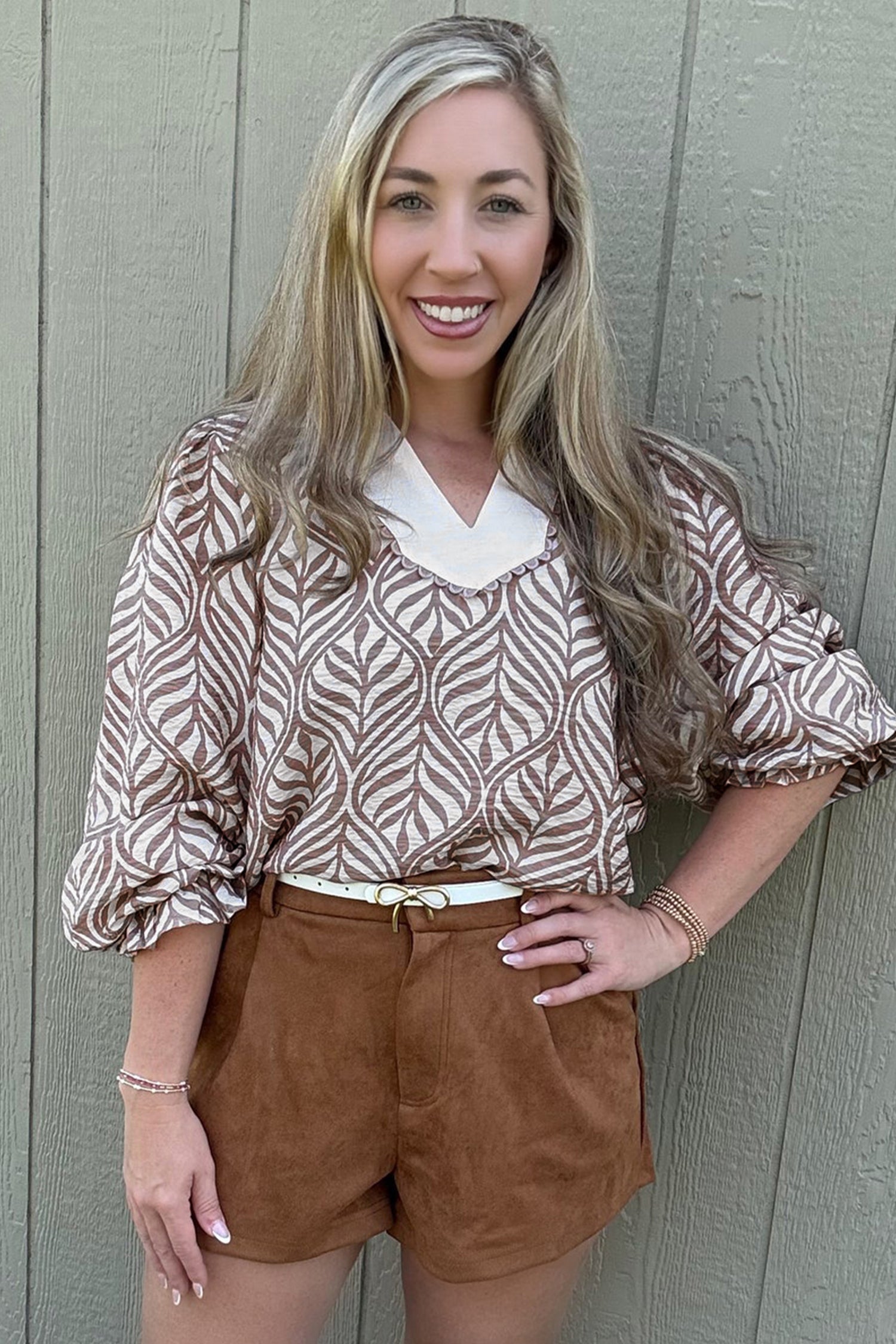 Top con cuello alto, mangas abullonadas y estampado de hojas marrones