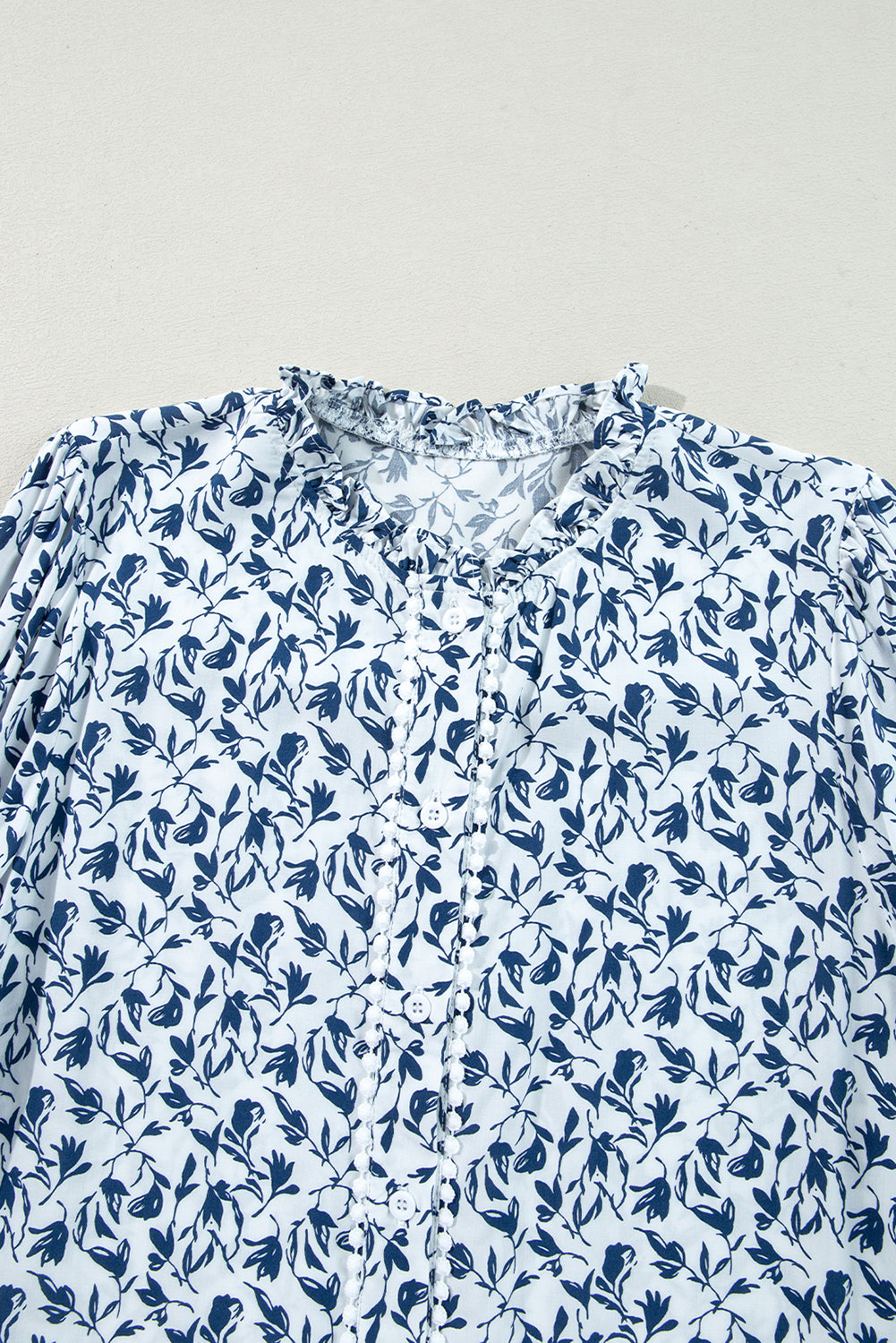 Camisa de otoño con mangas abullonadas, detalle de encaje y estampado floral azul