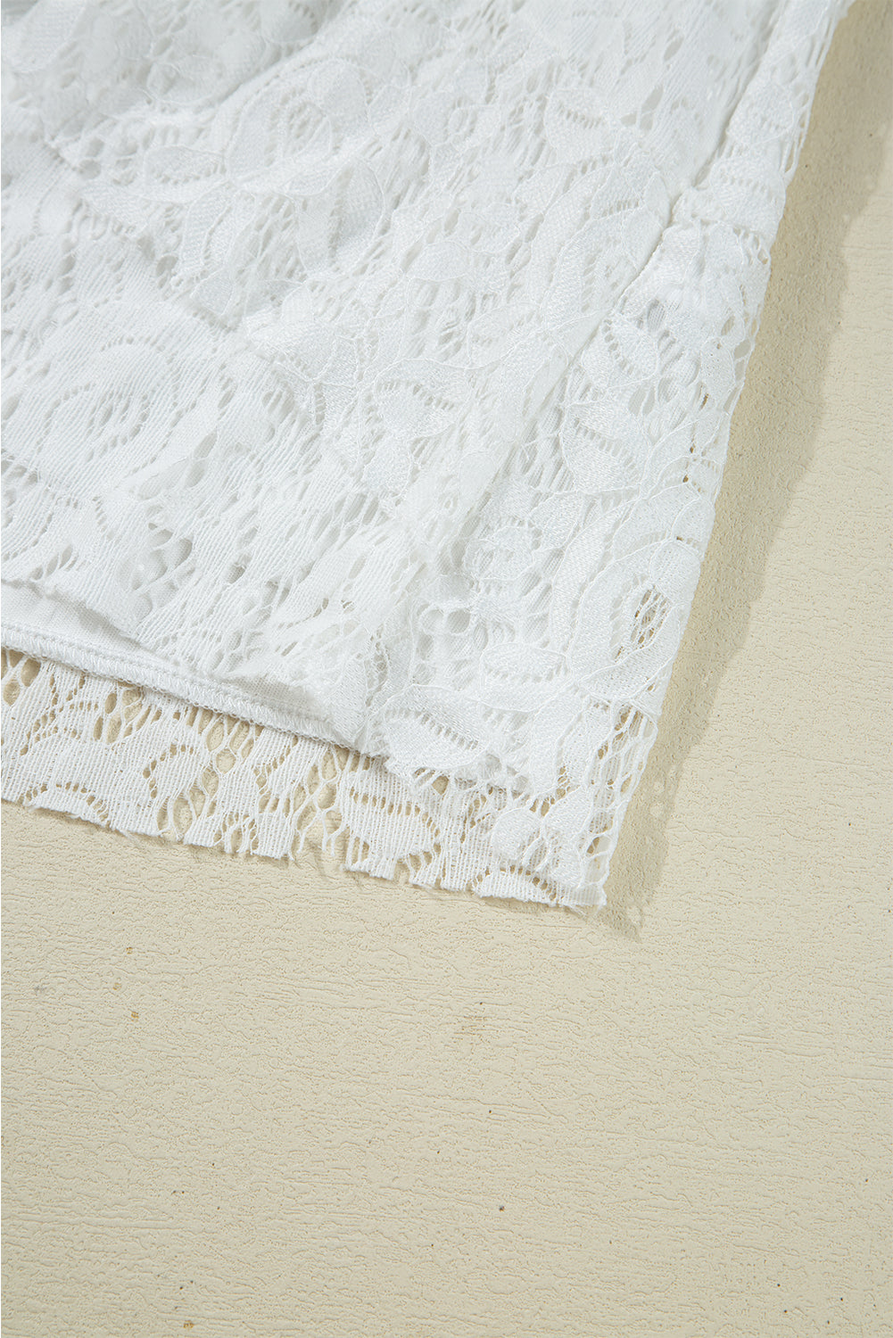 Blusa blanca de manga larga con escote en V, detalle de encaje y volantes, cuello en V y lazo.