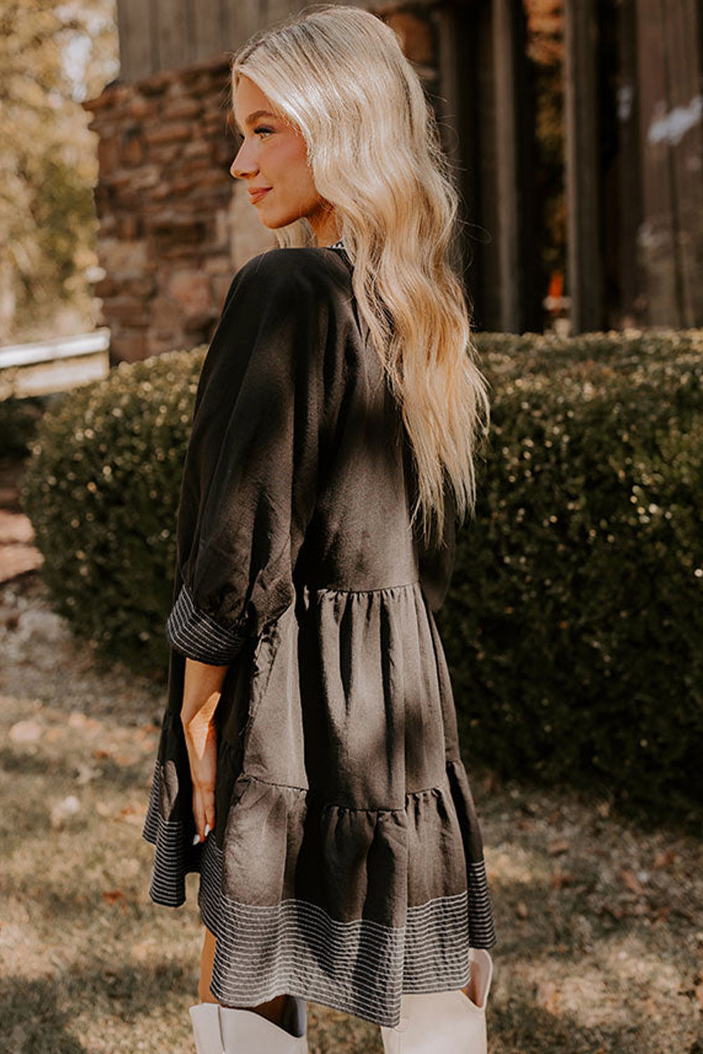 Vestido corto negro con escote en V y mangas 3/4 con costuras en contraste