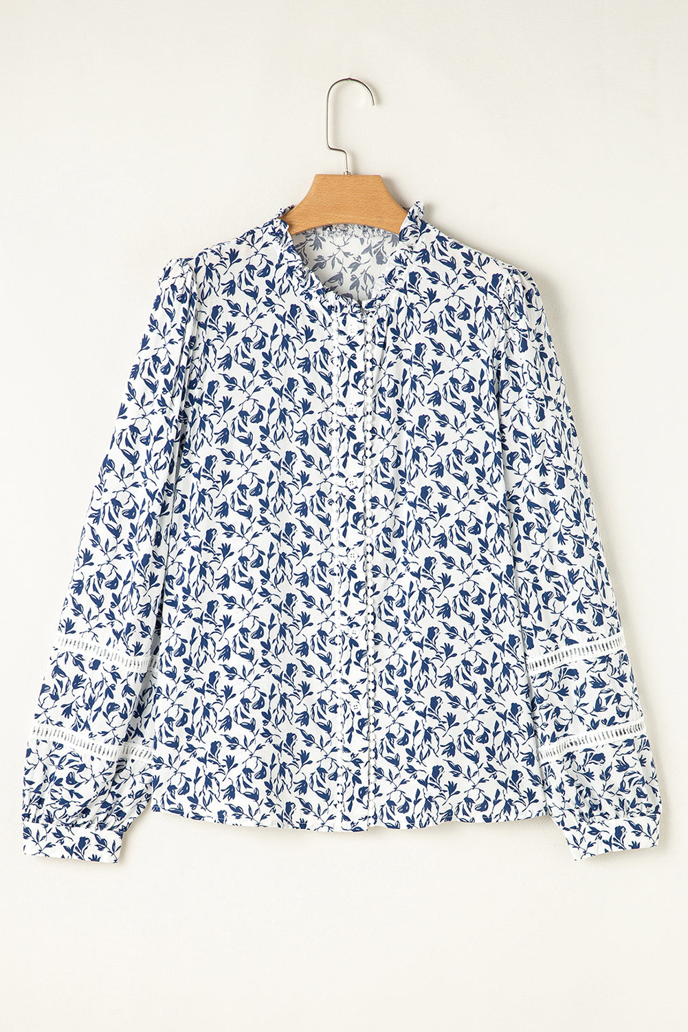 Camisa de otoño con mangas abullonadas, detalle de encaje y estampado floral azul