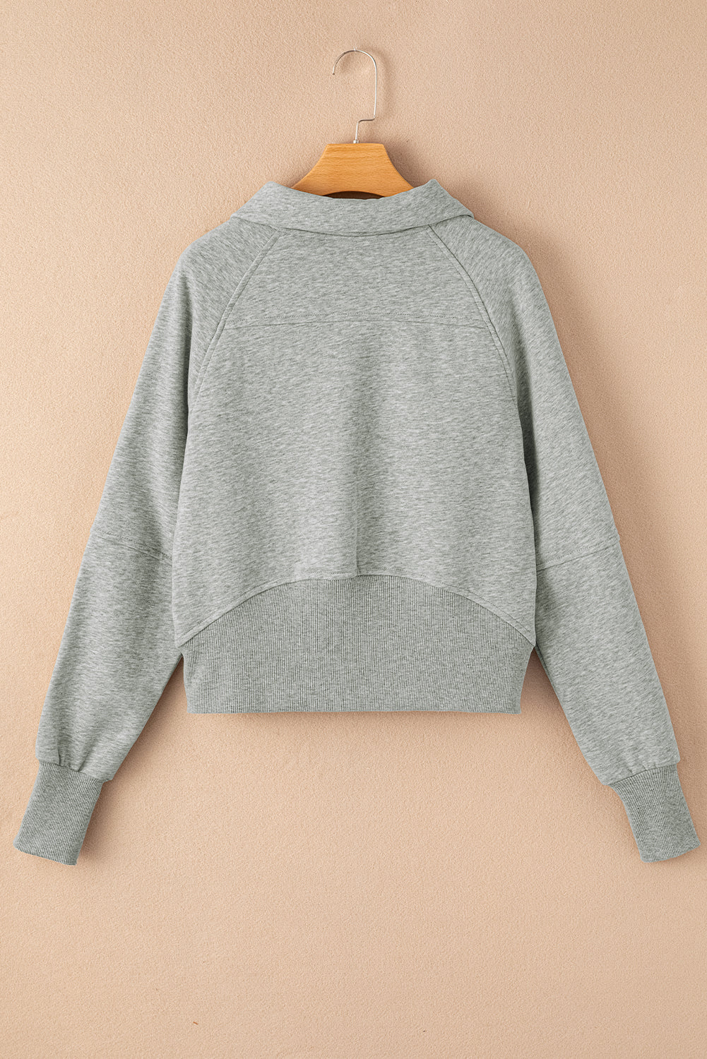 Sudadera gris con cuello alto, cremallera y mangas con abertura para los pulgares acanaladas