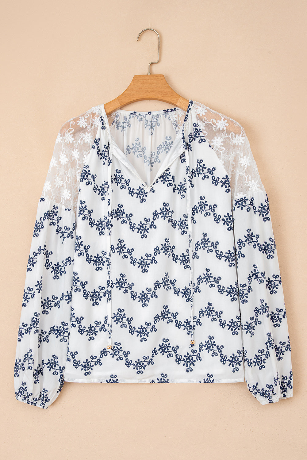 Blouse bleue en dentelle patchwork à motifs floraux, manches bouffantes et col V fendu, style patchwork à manches bouffantes.