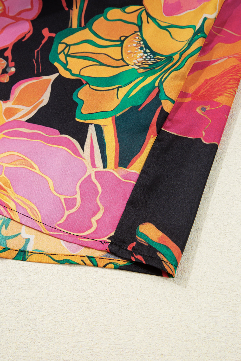 Blusa negra con estampado floral, puños fruncidos, mangas abullonadas y escote en V