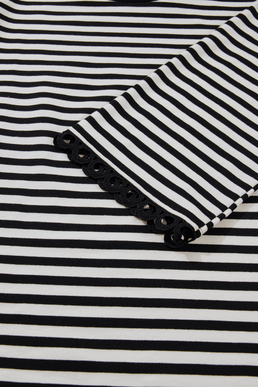 Top de rayas negras con cuello redondo y ribete en contraste y mangas acampanadas