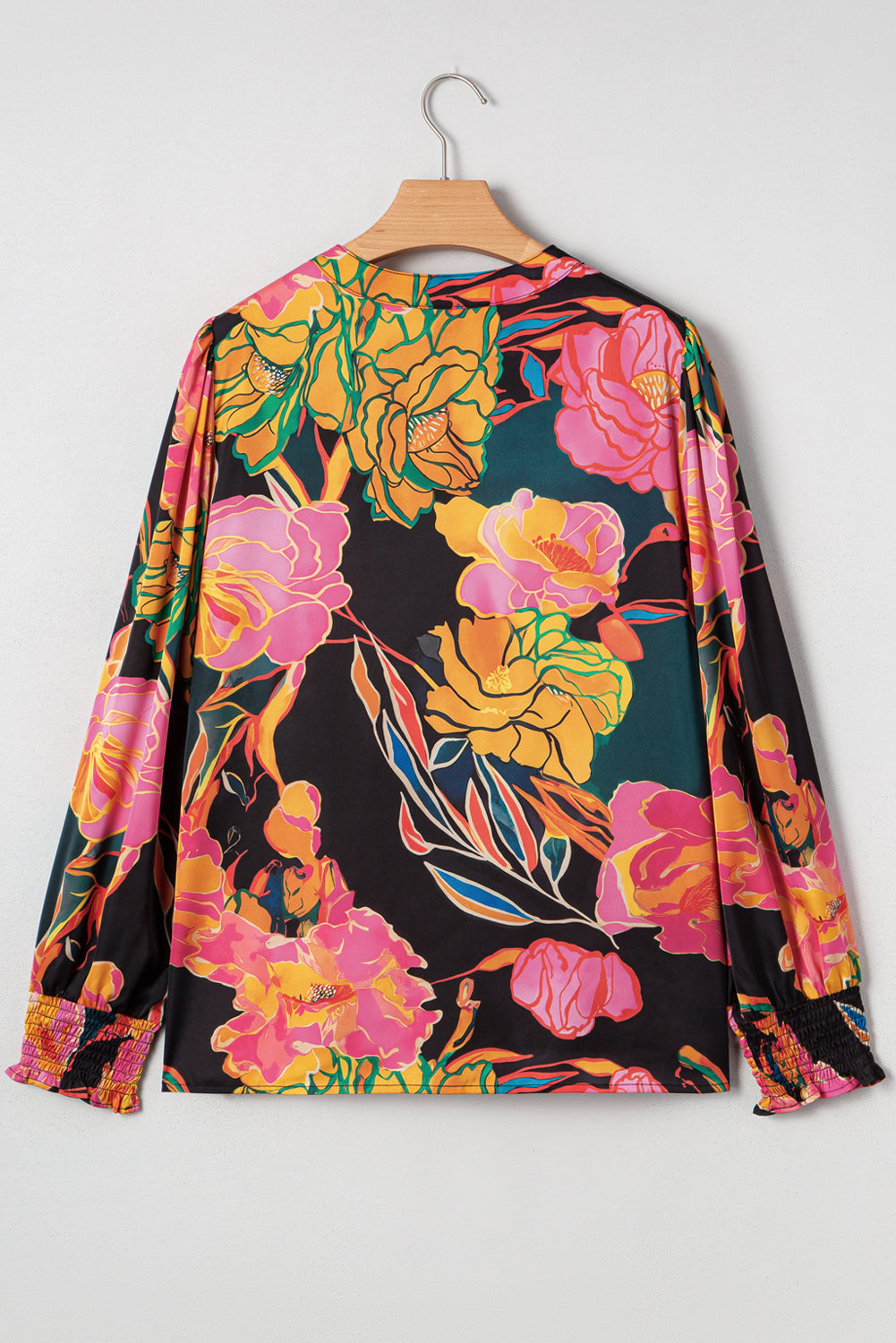 Blusa negra con estampado floral, puños fruncidos, mangas abullonadas y escote en V