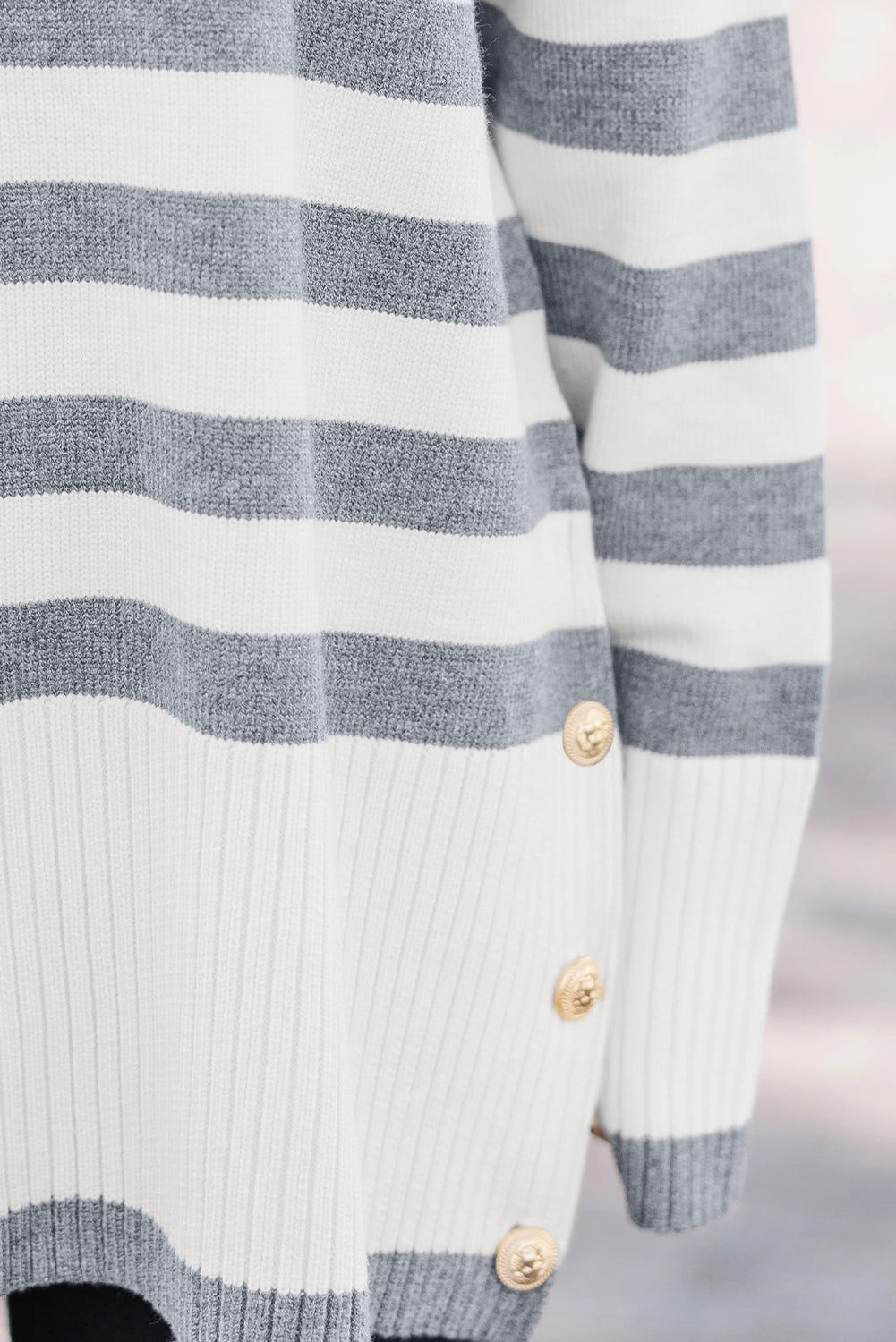 Suéter tipo túnica con hombros caídos, detalle de botones y canalé de rayas grises