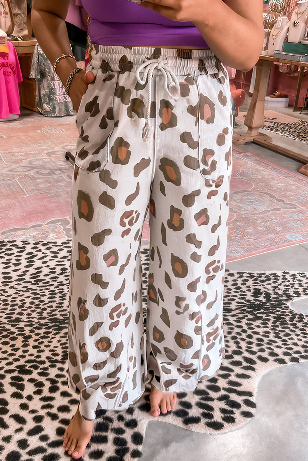 Pantalones holgados color beige con estampado de leopardo, cordón ajustable y bolsillos de parche.