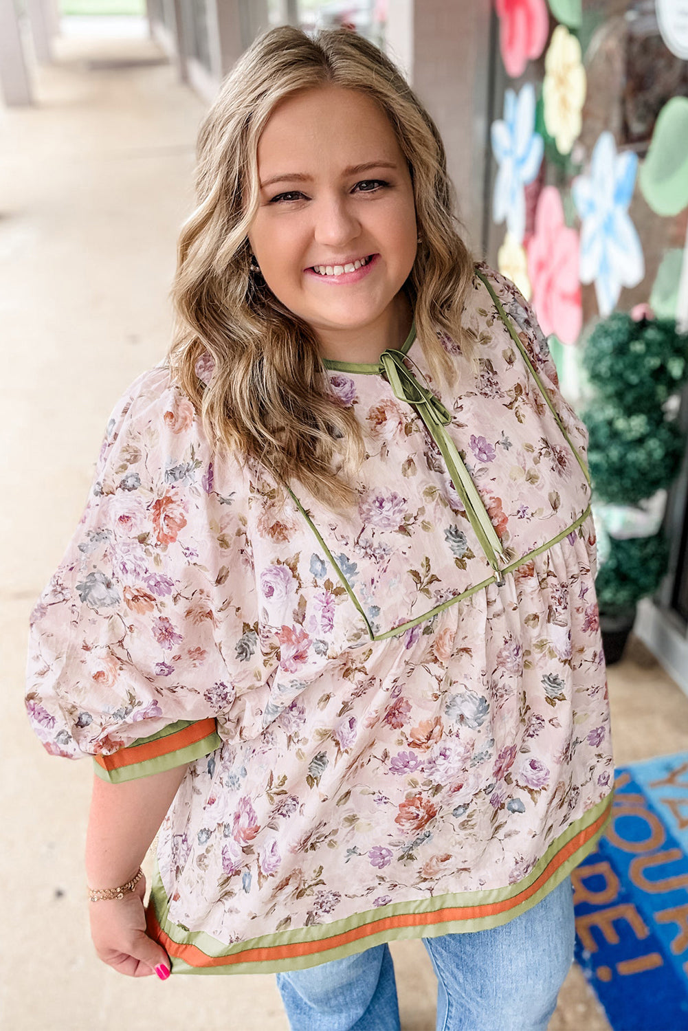 Blouse babydoll noire grande taille à imprimé floral, bordures contrastées et rayures.