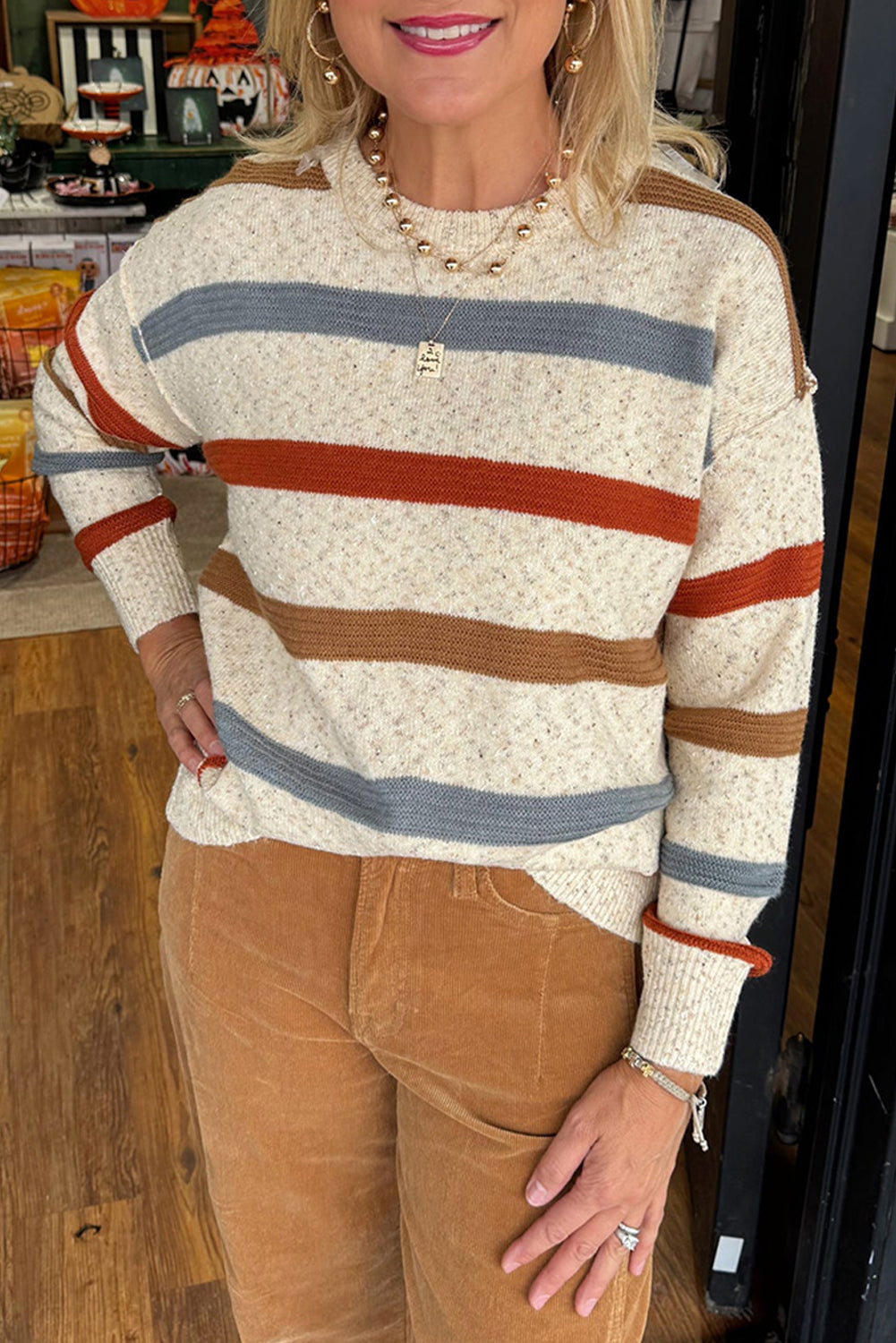 Pull en maille chinée beige à rayures, coutures apparentes et épaules tombantes