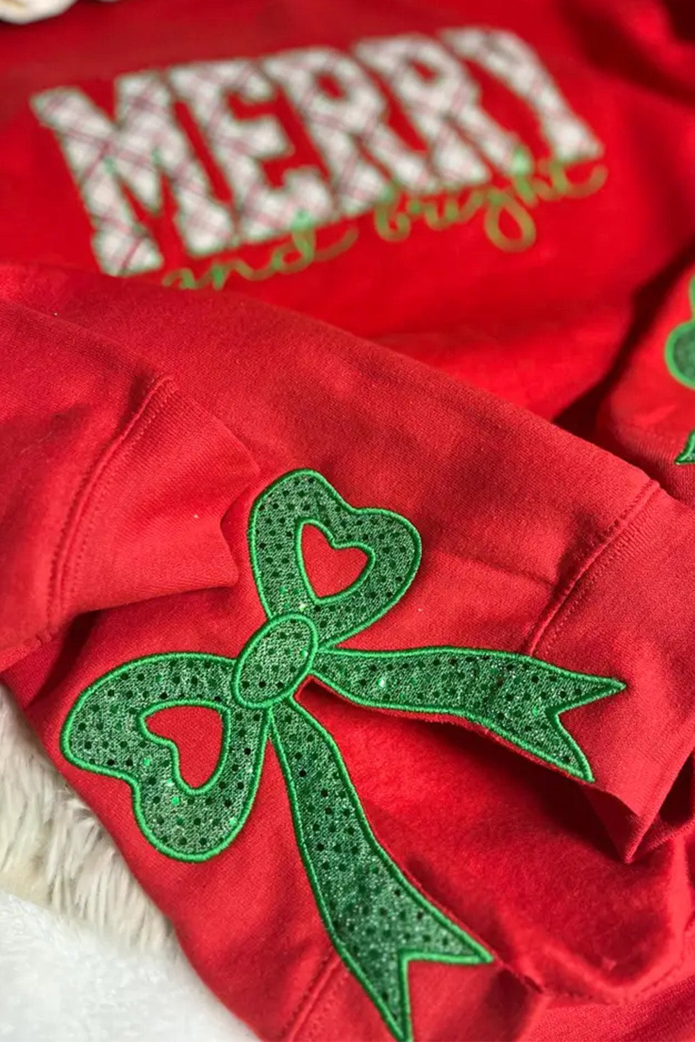Sweat-shirt de Noël rouge flamboyant à carreaux brodés de lettres et de sequins, avec nœud décoratif.