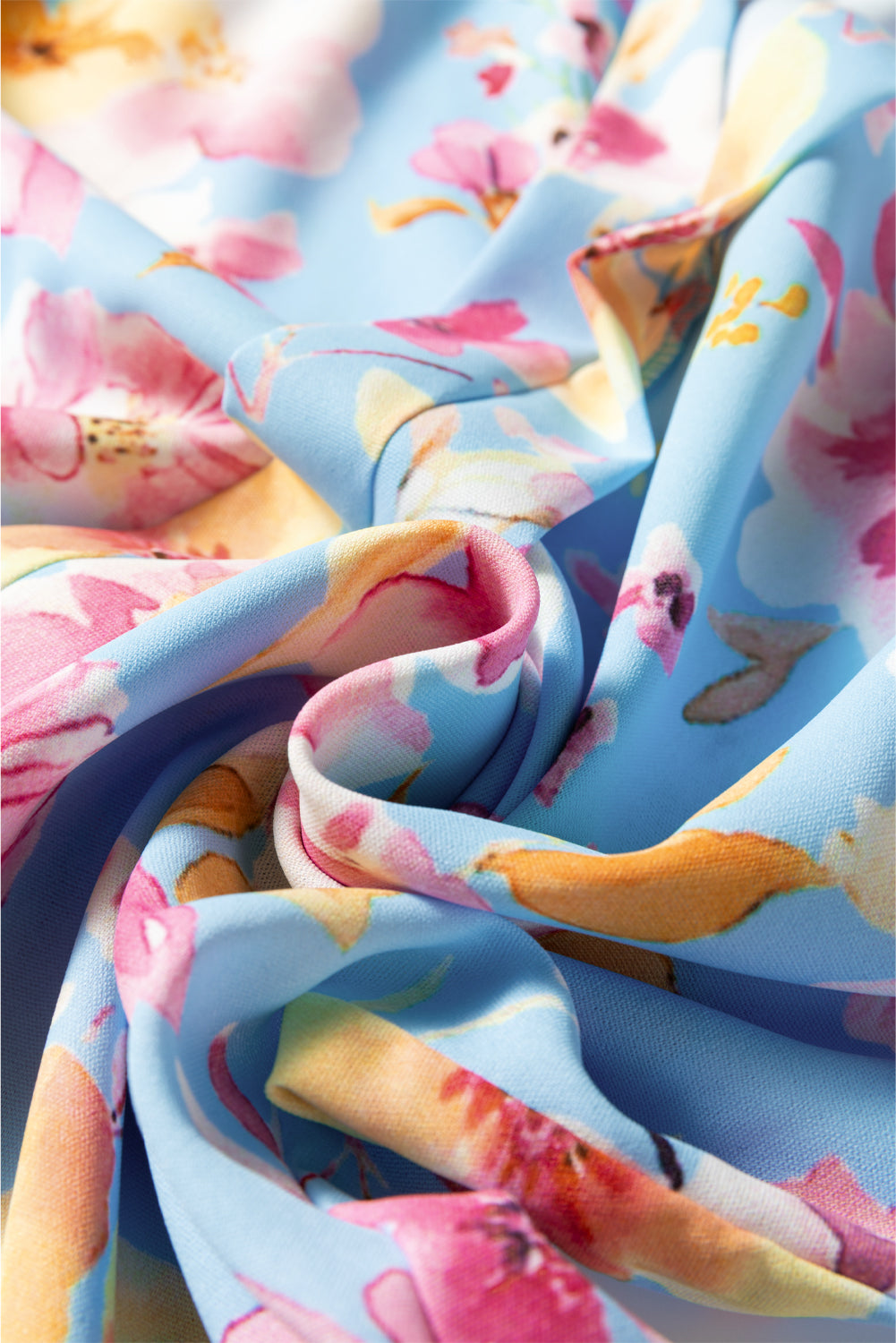 Chemisier bleu ciel à fleurs, poignets froncés, manches volantées, col en V