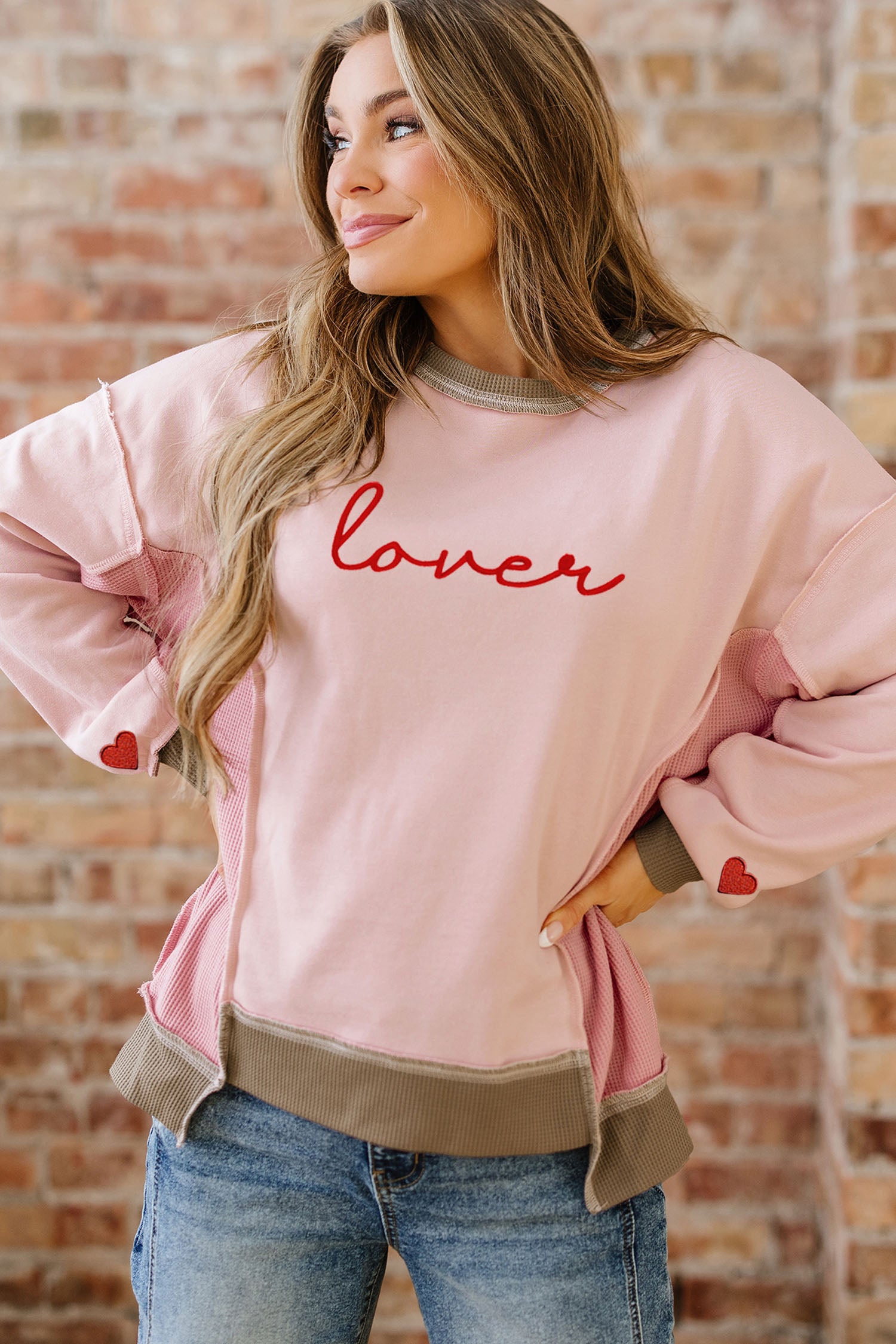 Sweat-shirt rose clair à empiècements gaufrés et broderies, idéal pour les amoureux des sweats à capuche.